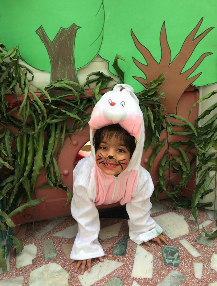 Child in bunny costume playing outdoors.